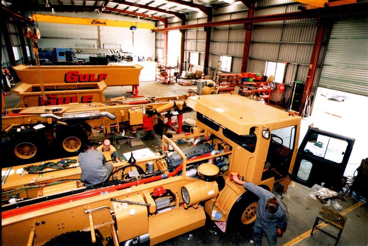 Gulf-branded plant being rebuilt on the workshop floor under an overhead crane