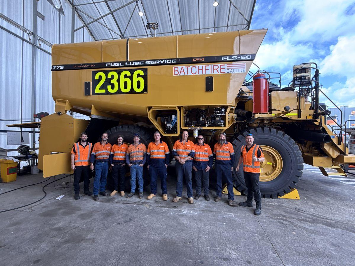 The QMW delivery crew standing in front of a Cat 775 fuel-lube service truck, unit 2366