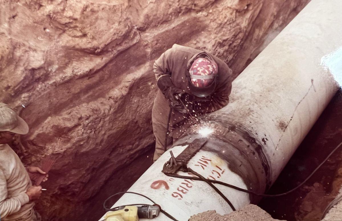 Close view of a pipeline joint being welded in the trench