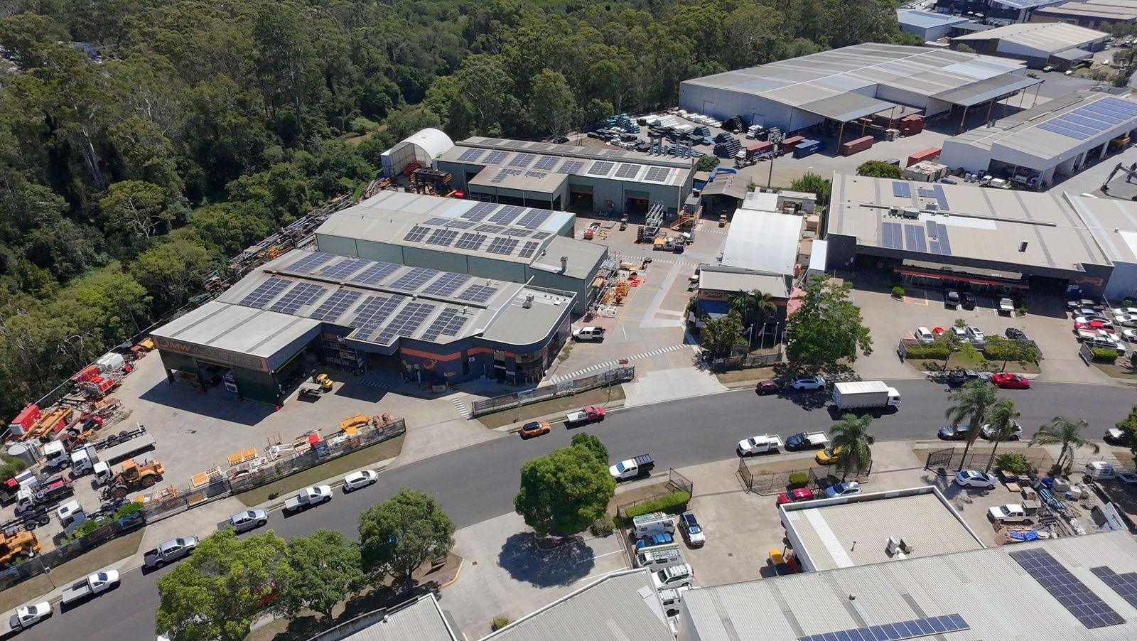 Drone view of 53 Success Street in February 2026: workshops with rooftop solar, the curved-roof front workshop and the yard